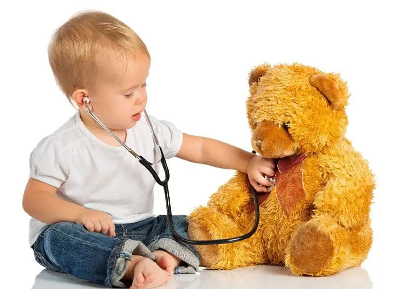 A baby is playing with a teddy bear