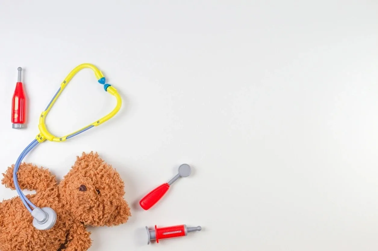 A stuffed animal and some toy tools on top of a table.