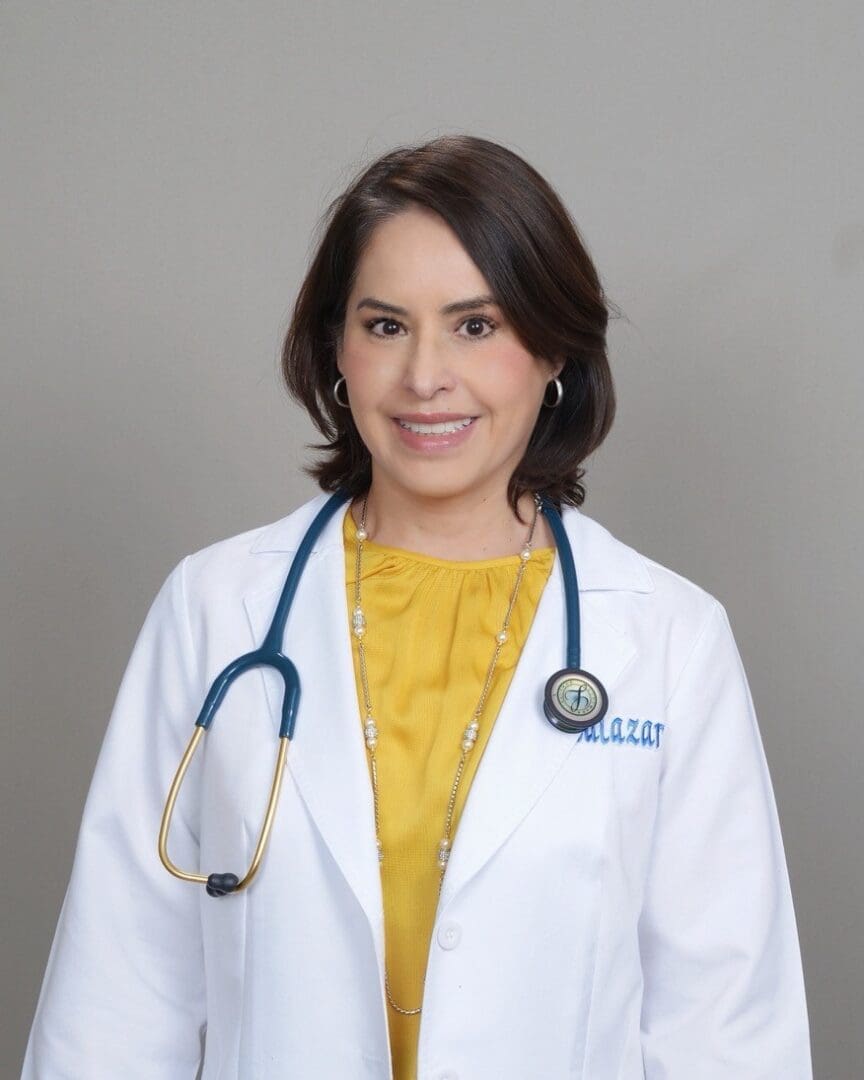 A woman in white coat and yellow shirt with stethoscope.